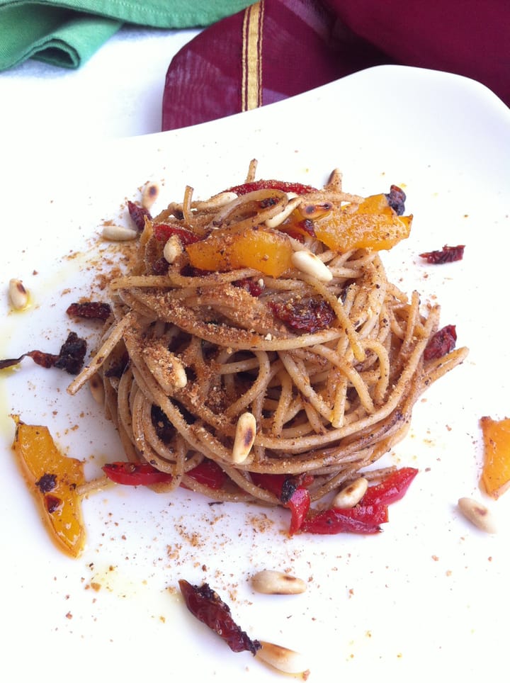 Spaghetti con pomodori secchi, pinoli, peperoni e patè d'olive